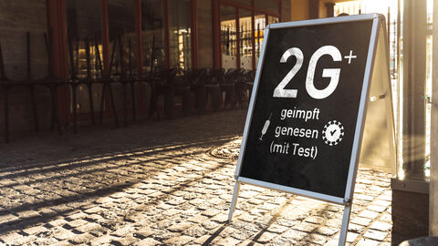 Hinweisschild zur 2G-Plus-Regelung vor einem Geschäft