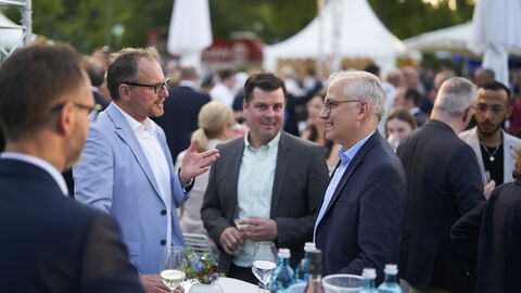 Aus Hessen hat von den Kabinettsmitgliedern und Mitgliedern des Hessischen Landtages unter anderem auch der stellvertretende Ministerpräsident, Tarek Al-Wazir, am Hessenfest in Berlin teilgenommen. Der stellvertretende Ministerpräsident, Tarek Al-Wazir, inmitten der Gäste auf dem Hessenfest in Berlin, an einem Stehtisch stehend im Gespräch mit zwei Gästen
