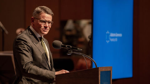 Ministerpräsident Boris Rhein steht an einem Rednerpult im HR-Sendesaal und redet zu den Teilnehmerinnen und Teilnehmern des Festakts aus Anlass des 75-jährigen Bestehens der Jüdischen Gemeinde Frankfurt.