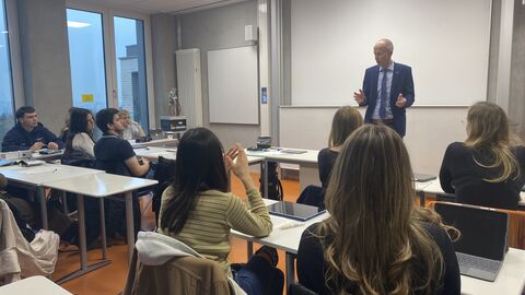 Bildungsminister Schwarz steht vor einer Schulklasse und spricht. Hinter ihm ein Whiteboard, vor ihm Schüler, die ihn anschauen.
