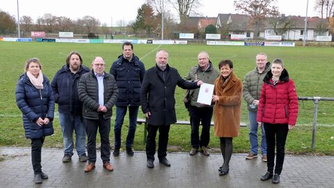 Europaministerin Lucia Puttrich bei der Übergabe des Förderbescheides an den Bürgermeister der Stadt Friedberg, Dirk Antkowiak, und mit Mitgliedern des Sportvereins FC Olympia Fauerbach. 