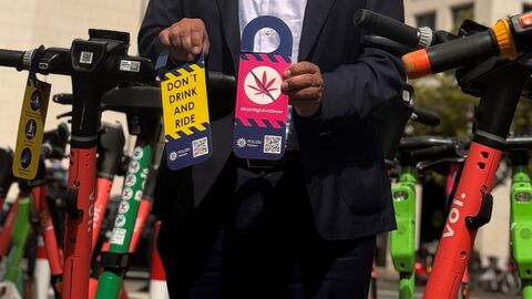 Mann steht neben E-Scootern